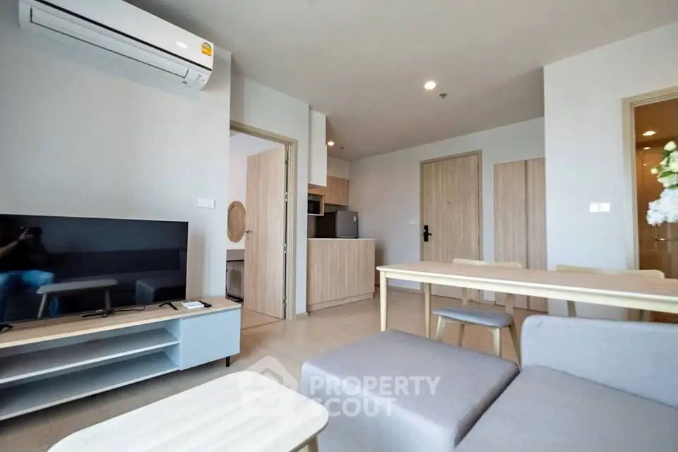 Modern living room with open kitchen and stylish furniture in a cozy apartment.