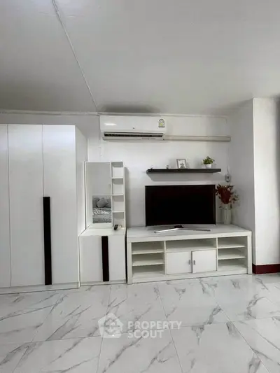 Modern living room with sleek white furniture and marble flooring