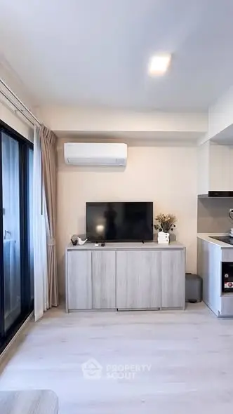 Modern living room with sleek TV setup and air conditioning, featuring a minimalist design and natural light.