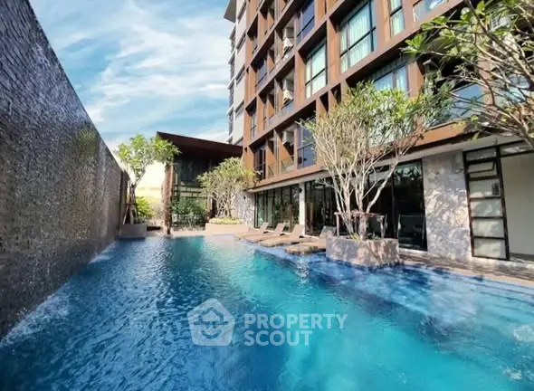 Luxurious apartment building with stunning pool and modern architecture.