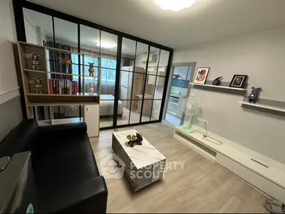 Modern living room with glass partition, sleek furniture, and stylish decor