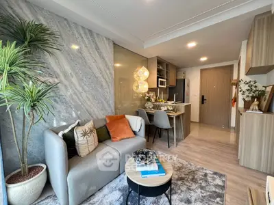 Modern living room with open kitchen, stylish decor, and cozy seating area in a contemporary apartment.