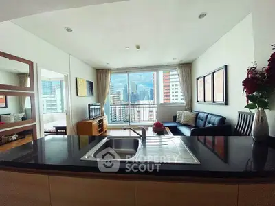 Modern open-plan living room with city view, featuring sleek kitchen island and cozy seating area.