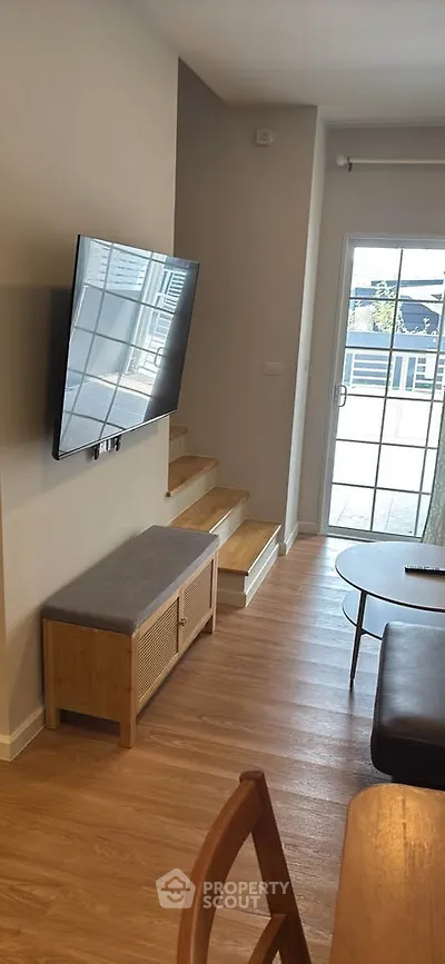 Modern living room with wall-mounted TV and stylish furniture
