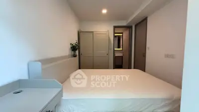 Modern bedroom with minimalist design and neutral tones, featuring a cozy bed and sleek wardrobe.