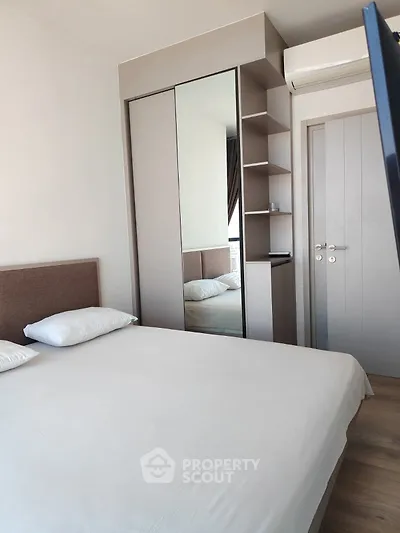 Modern bedroom with mirrored wardrobe and air conditioning unit