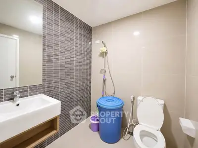 Modern bathroom with sleek design and contemporary fixtures, featuring a stylish sink and shower area.