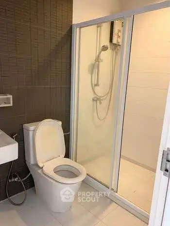Modern bathroom with sleek shower and toilet in contemporary design.