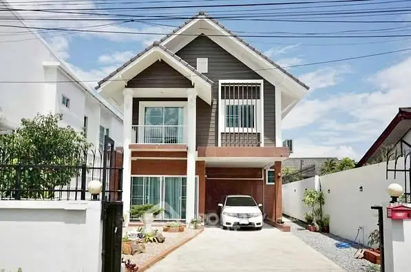 Charming two-story house with driveway and car, featuring modern design and lush garden.