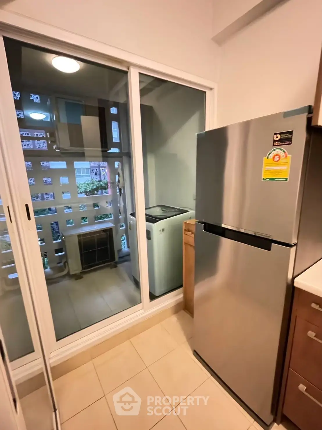 Modern kitchen with stainless steel fridge and laundry area view