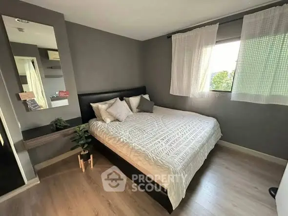 Cozy bedroom with modern decor and large window for natural light.