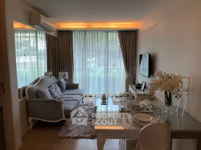 Elegant living room with modern decor, large windows, and stylish furniture in a cozy apartment.
