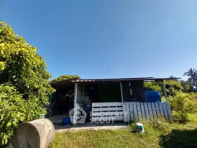 Charming rustic house with lush greenery and clear blue sky, perfect for nature lovers.