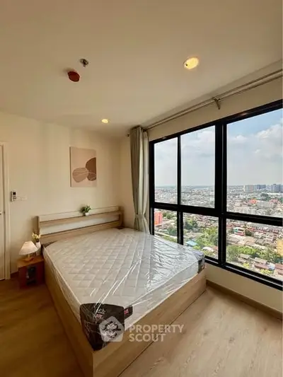 Modern bedroom with large window offering stunning city view