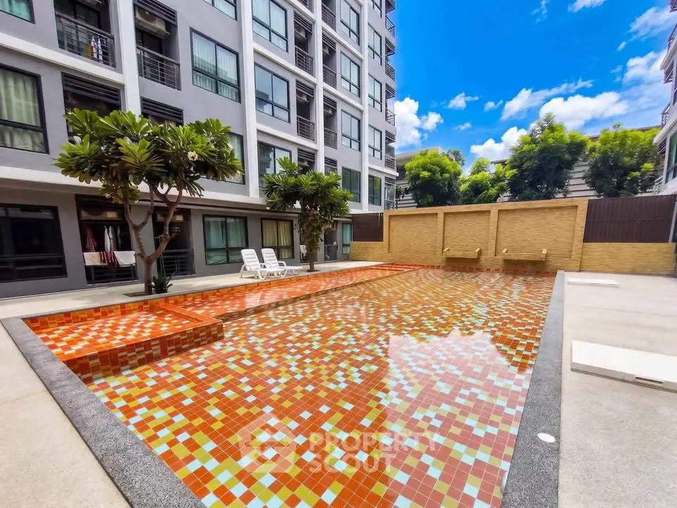 Modern apartment building with vibrant outdoor pool and lush greenery
