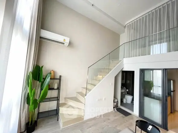 Modern duplex living room with staircase and large windows