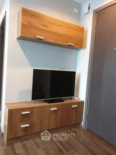 Modern living room with sleek wooden TV cabinet and wall-mounted storage.