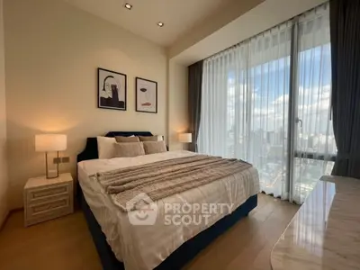 Luxurious bedroom with city view, featuring elegant decor and large windows for natural light.