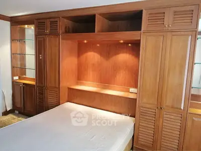 Spacious bedroom with built-in wooden wardrobe and cozy lighting