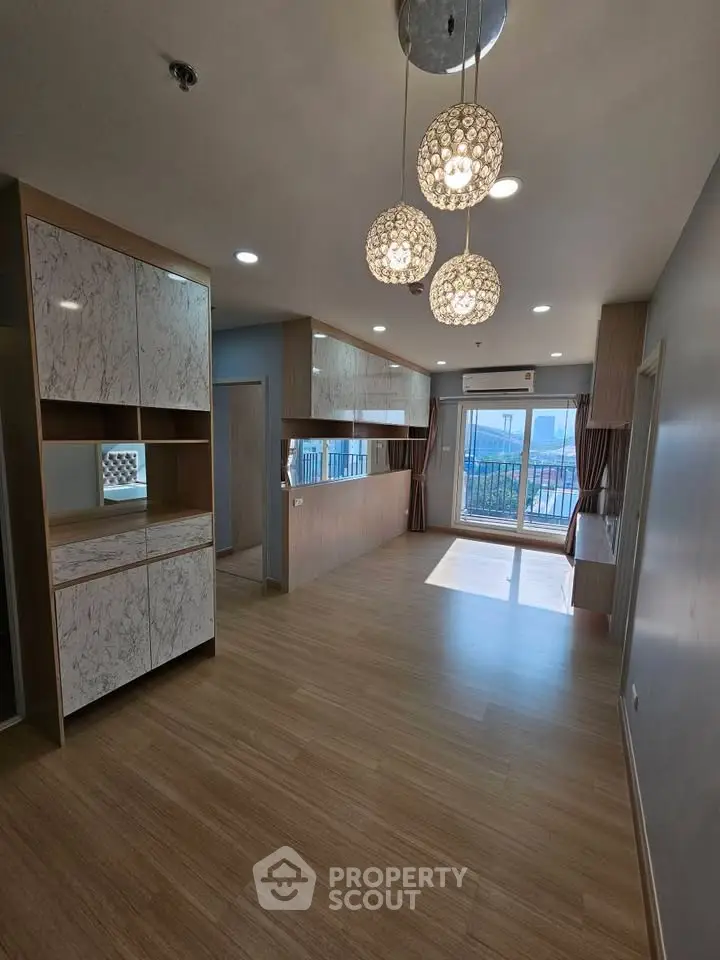 Spacious modern living room with elegant lighting and large windows offering a stunning view.