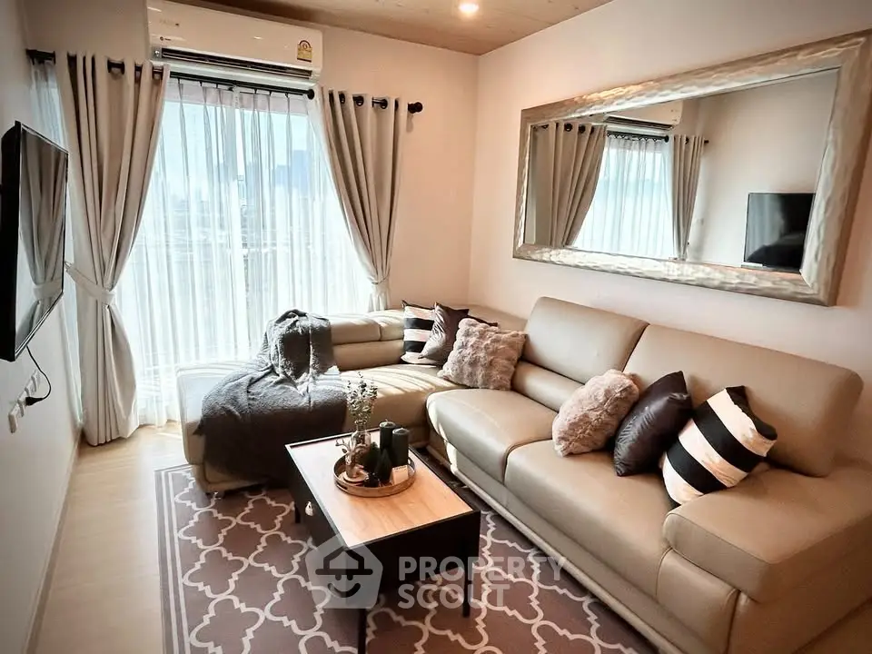 Stylish living room with cozy seating and large window offering natural light.