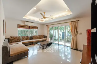 Spacious living room with modern decor and garden view, perfect for relaxation and entertaining.