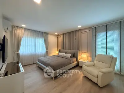 Luxurious bedroom with modern decor, featuring a plush bed, cozy armchair, and ambient lighting.