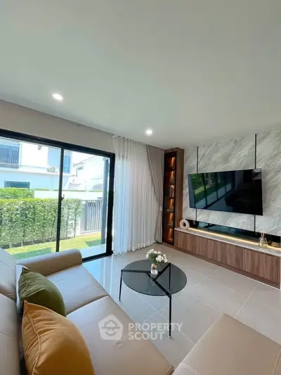 Modern living room with large window, stylish furniture, and garden view, perfect for relaxation and entertainment.