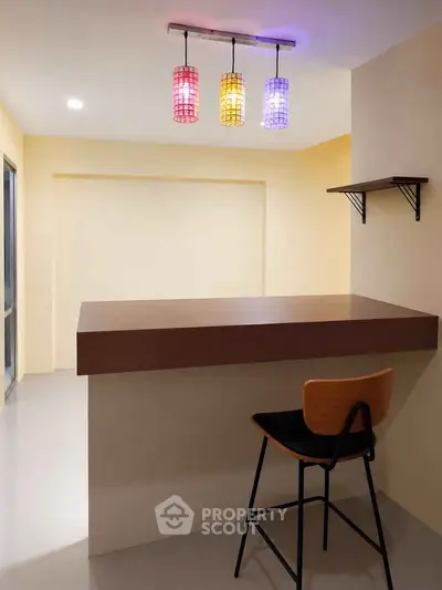 Modern minimalist kitchen with stylish bar counter and colorful pendant lights