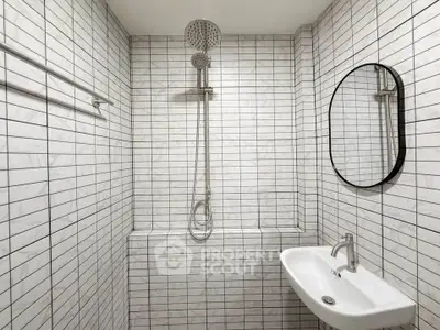 Modern minimalist bathroom with sleek shower and stylish sink in white tile design.