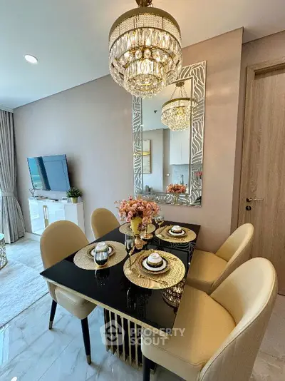 Elegant dining area with chic chandelier and modern decor in a stylish apartment.