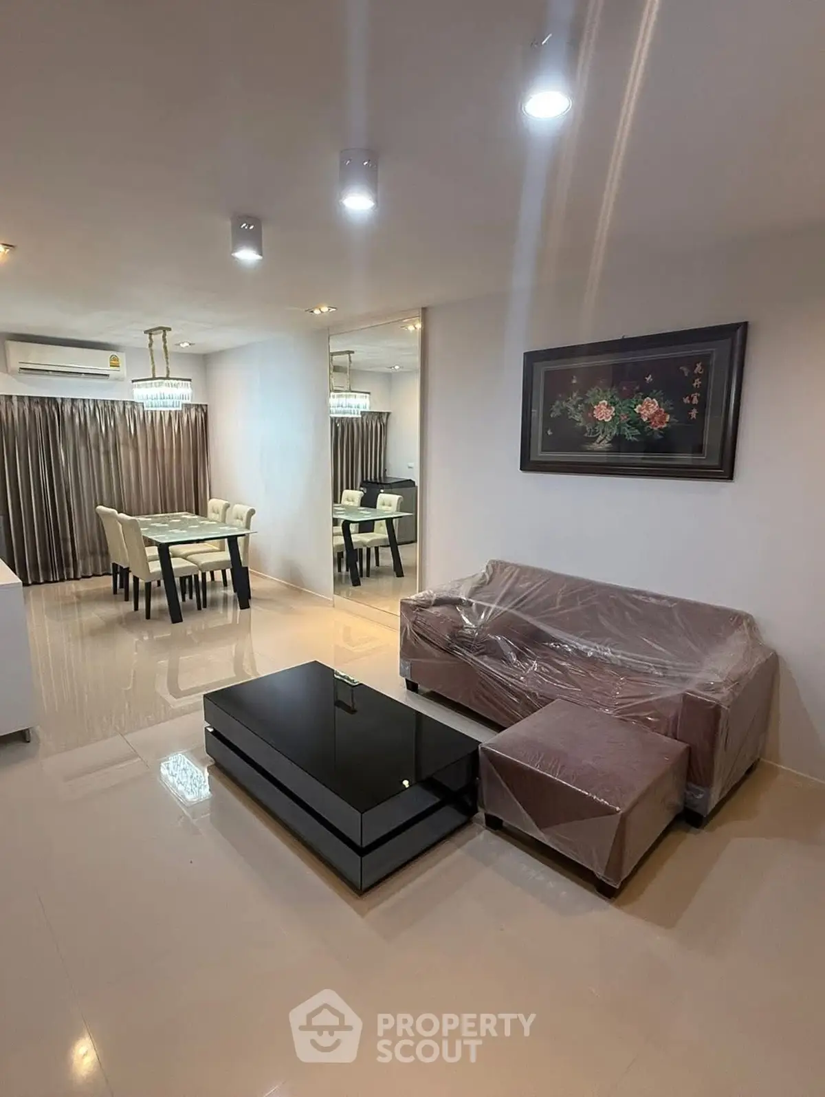 Modern living room with dining area, elegant lighting, and sleek furniture.