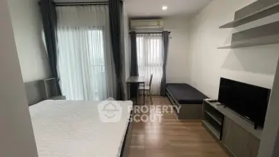 Modern bedroom with natural light, featuring a bed, TV, and desk in a cozy apartment setting.