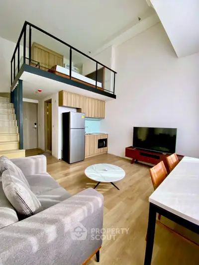 Modern loft apartment with open layout, stylish furniture, and mezzanine bedroom.