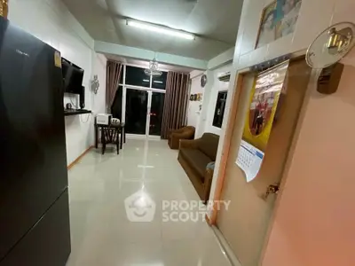 Spacious living room with modern furnishings and large window offering natural light.