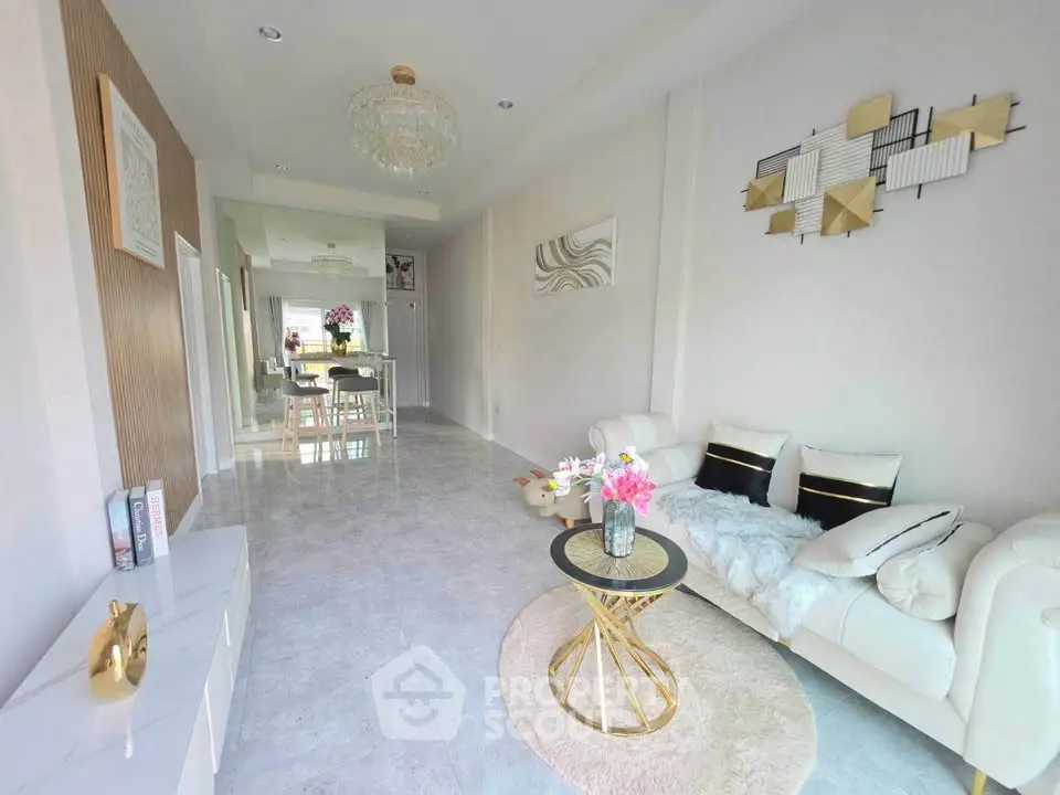 Elegant living room with modern decor and open layout, featuring stylish furniture and chic lighting.