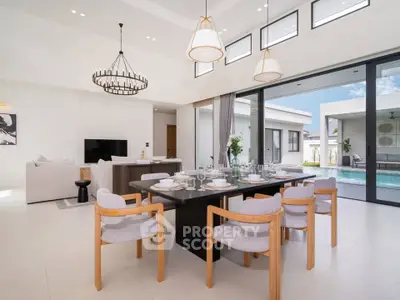 Luxurious open-plan dining and living area with pool view, modern decor, and elegant lighting.