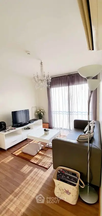 Charming living room with elegant chandelier and cozy seating area, perfect for relaxation.