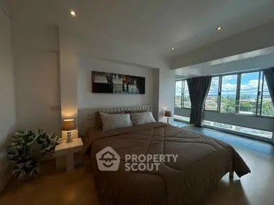 Spacious bedroom with large windows offering stunning views and modern decor.