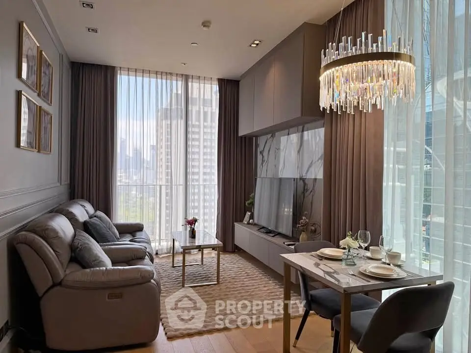 Luxurious modern living room with city view, elegant chandelier, and stylish decor in high-rise apartment.