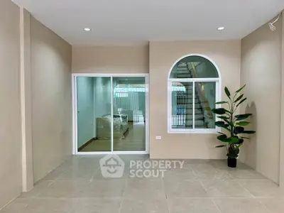 Spacious modern interior with large window and sliding glass door, perfect for natural light.