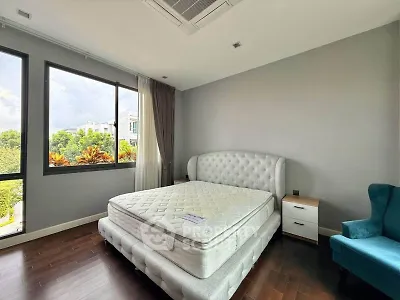 Spacious bedroom with large windows and elegant furniture in modern home.