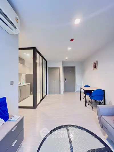 Modern open-plan living room with glass partition and stylish furniture