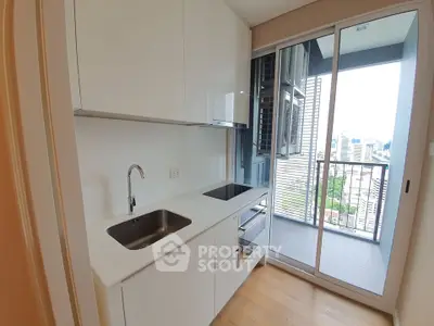 Modern kitchen with sleek white cabinets and balcony view