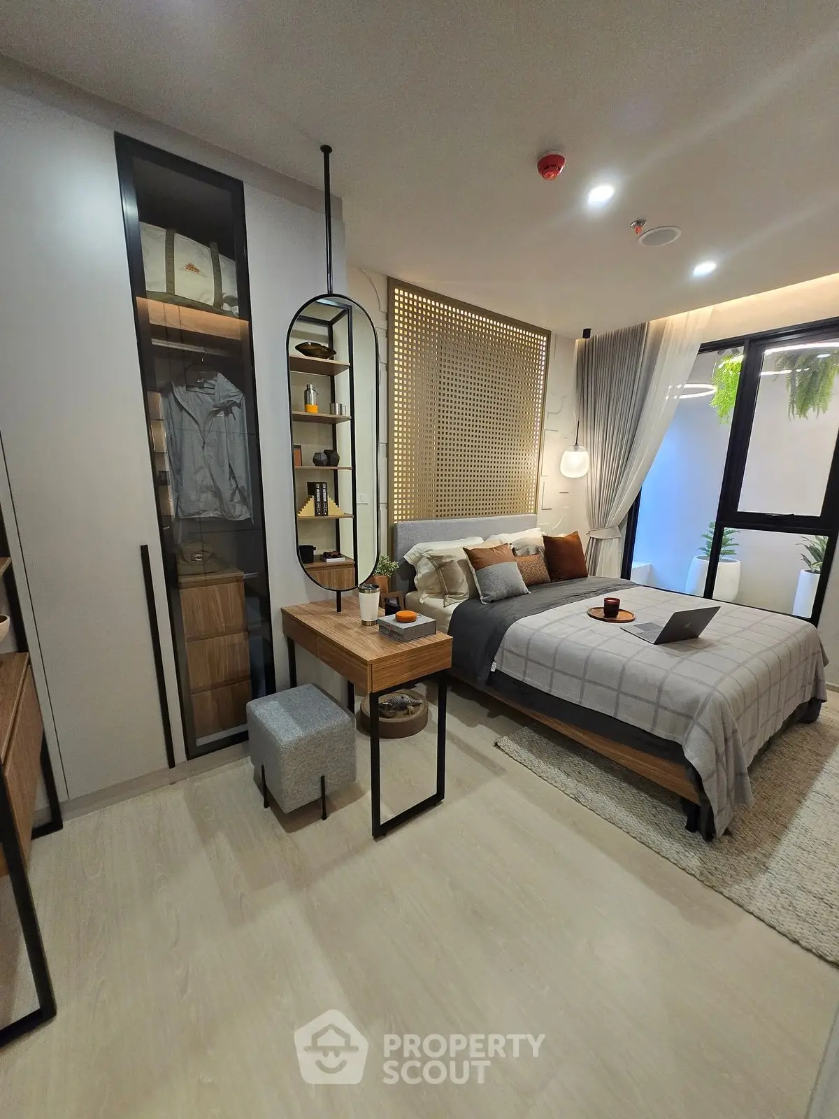Modern bedroom with stylish decor and natural light, featuring a cozy bed and sleek furniture.