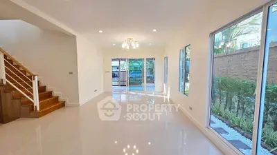 Spacious modern living room with large windows and garden view, perfect for family gatherings.
