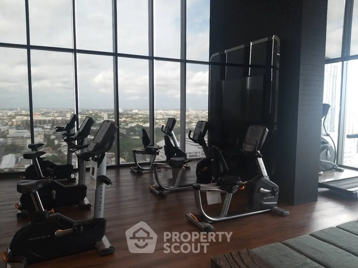 Modern high-rise gym with panoramic city views and state-of-the-art equipment.