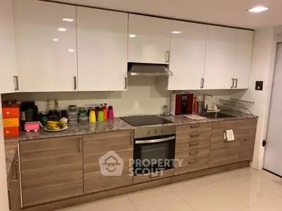 Modern kitchen with sleek cabinets and built-in oven, perfect for culinary enthusiasts.
