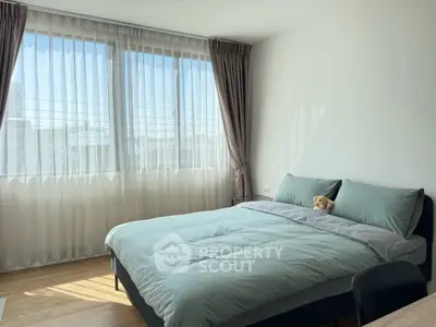 Bright and cozy bedroom with large window and modern decor