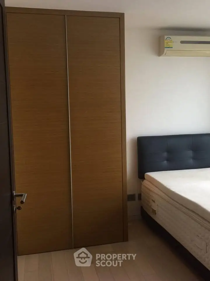 Cozy bedroom with built-in wardrobe and air conditioning unit.